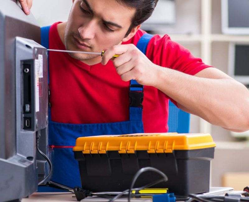 Professional repair engineer repairing broken tv
