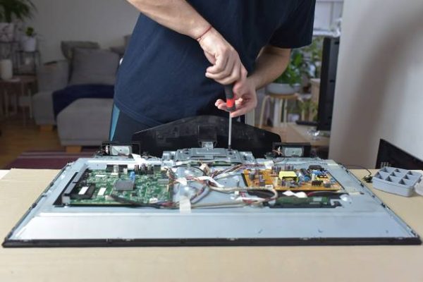 The man repairing broken tv at home